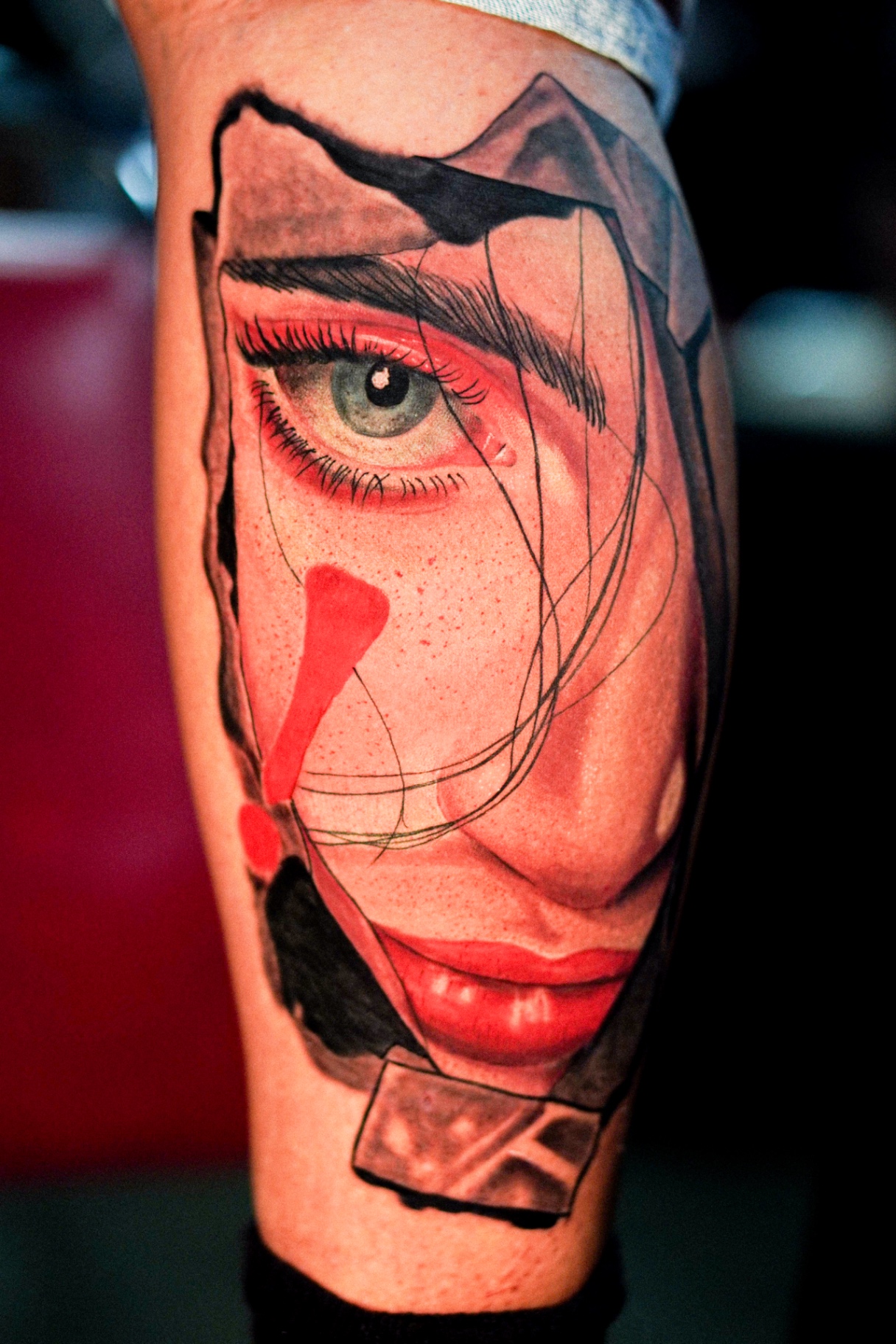 Color realism forearm piece with an abstract eye and lips by Ramón Santiago at R INKS ARTS