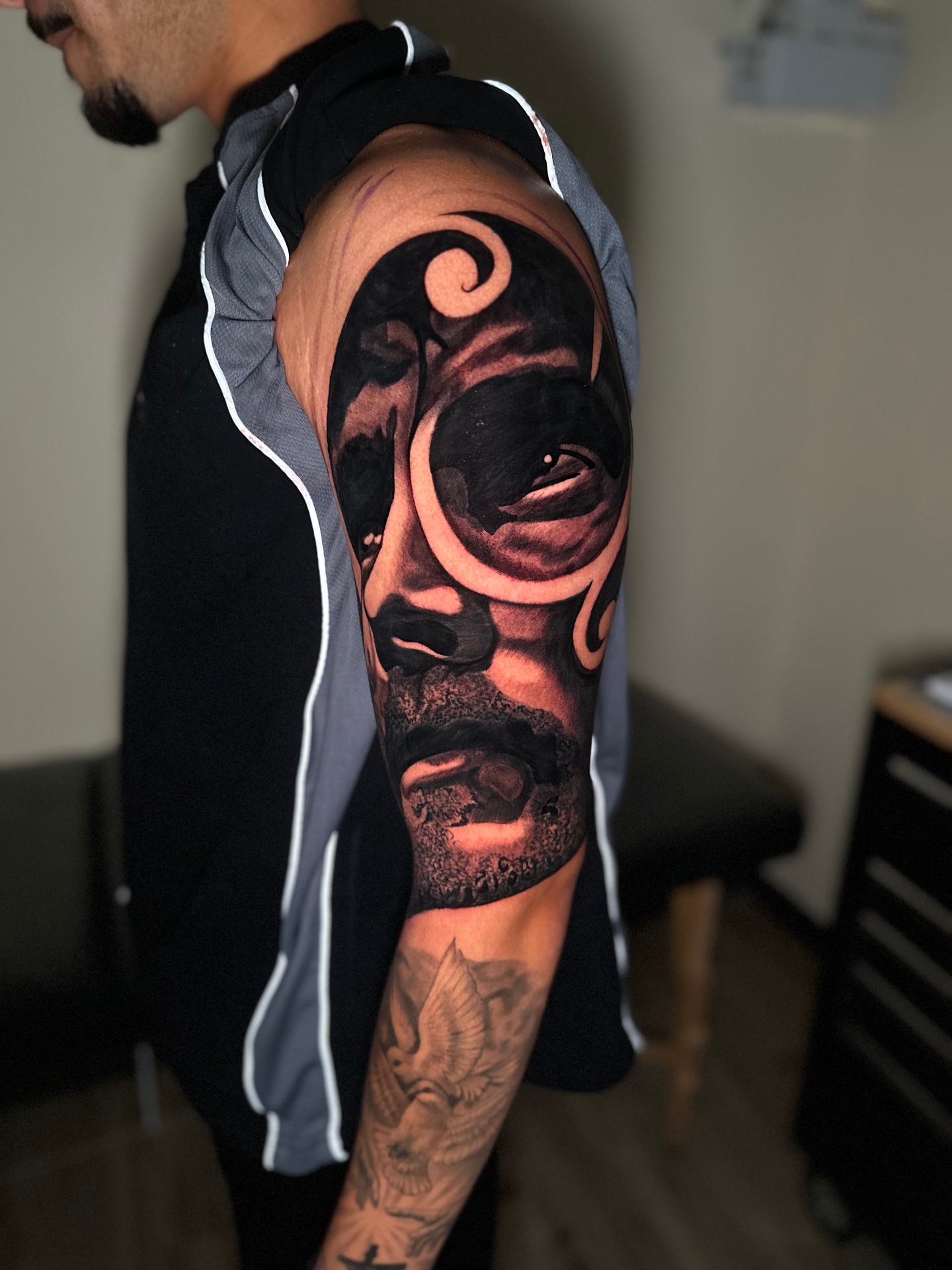 Black and grey sleeve with Maori-inspired design and a shaded face by Ramón Santiago at R INKS ARTS