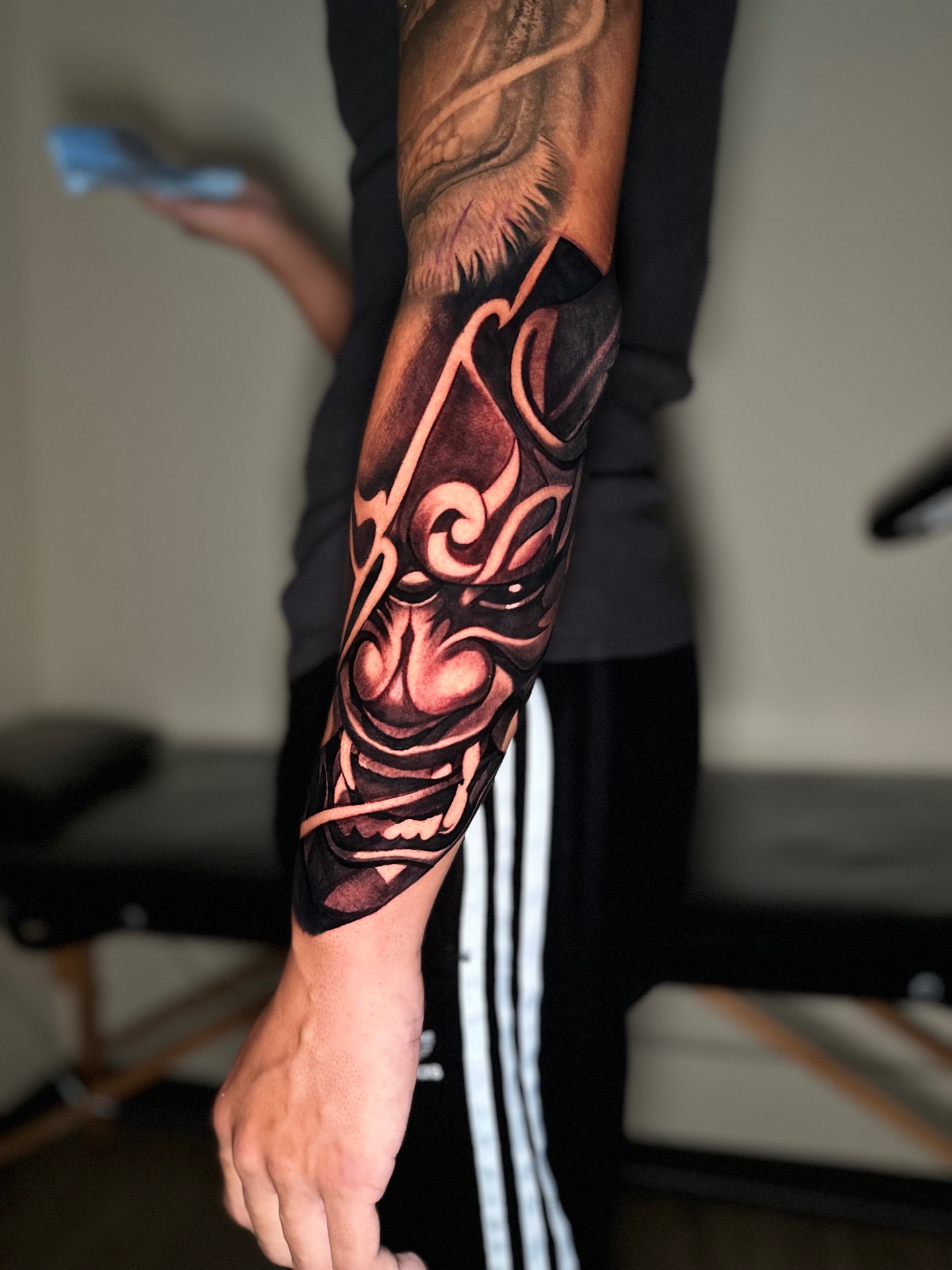 Black and grey hannya mask forearm tattoo by Ramón Santiago at R INKS ARTS